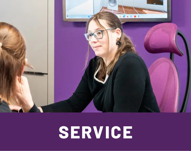 Mitarbeiterin vom Kuechenhaus Gruber beraet Kundin an Schreibtisch