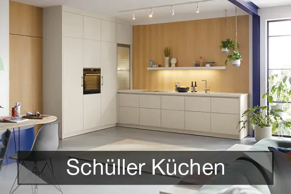 Helle Einbauküche mit Holzrückwand, Schriftzug „Schüller Küchen“.