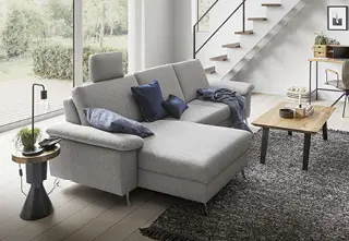 Hellgraues Stoffsofa in hellem Wohnzimmer