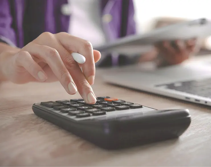 Nahaufnahme einer Hand die Werte in Taschenrechner eingibt