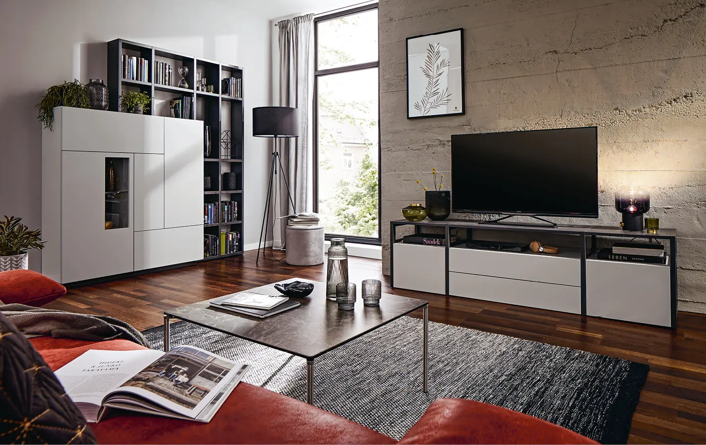 Weisse Wohnwand mit atmosphaerischer Beleuchtung in gemuetlichem Wohnzimmer