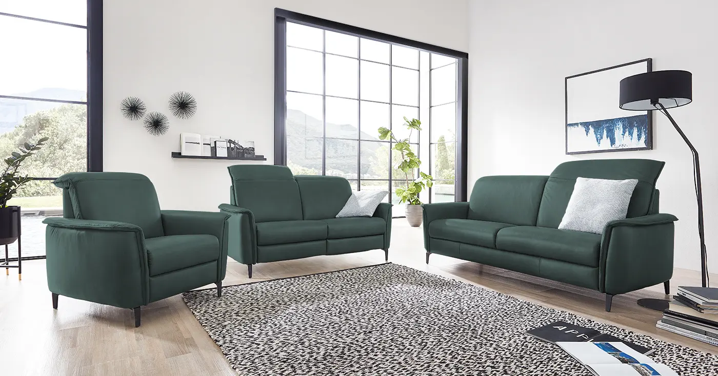Zwei grüne Ledersofa Garnituren mit verstellbarer Kopfstütze und einem dazu passenden Sessel.