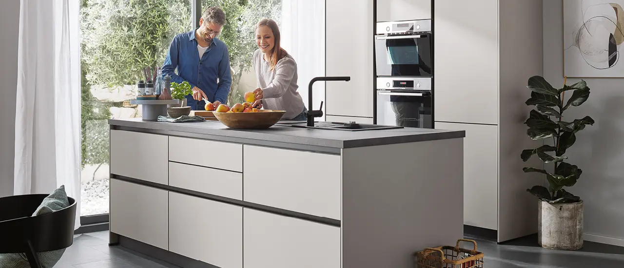 Minimalistische Inselküche mit grauen Fronten