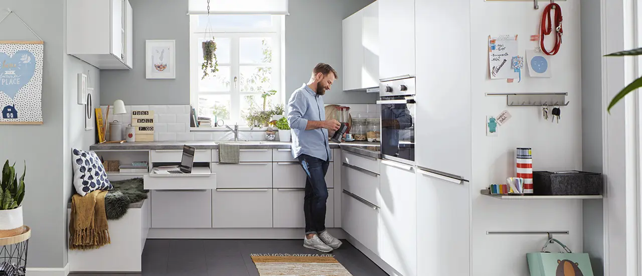 Kompakte Winkelküche mit Steinarbeitsplatte und weißen Küchenfronten