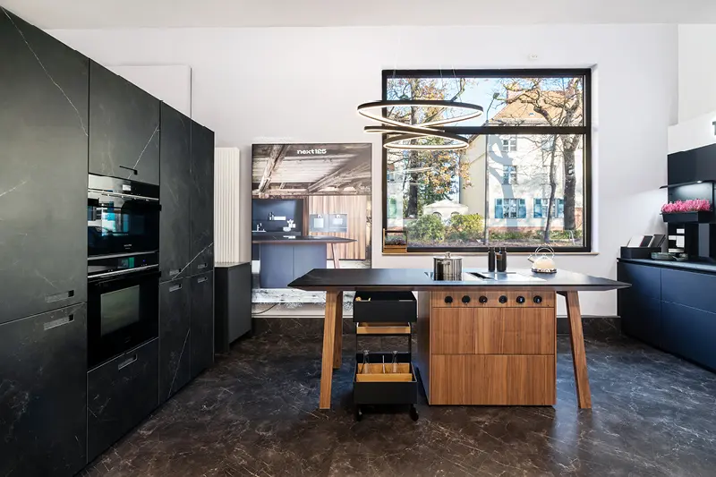 Anthrazitfarbene Inselkuche im Steinlook mit hoelzerner Kuecheninsel im Kuechenhaus Gruber