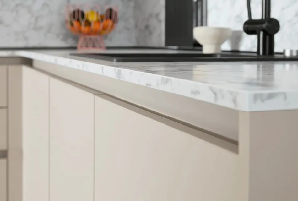 Detail der Arbeitsplatte in Marmoroptik mit Spüle in kleiner Küche.