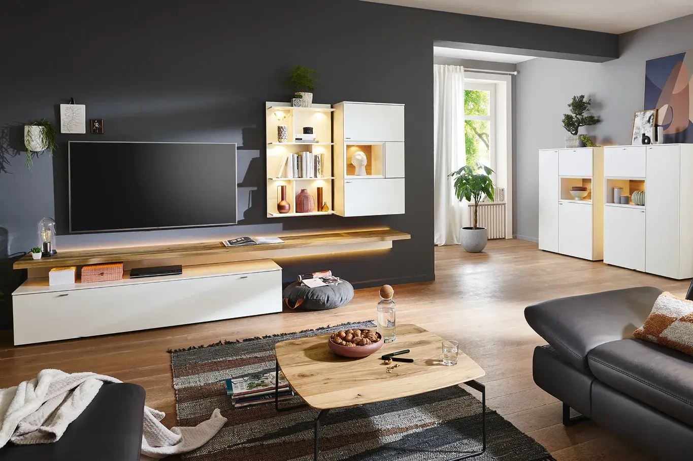 Weisse Wohnwand mit Holzakzenten und passendem Highboard in modernem Wohnzimmer