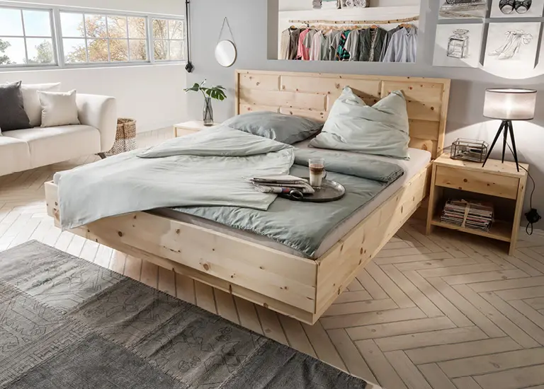 Schlafzimmer mit Massivholzbett, Nachttisch und heller Bettwäsche. Modernes Bett aus Naturholz mit gemütlicher Einrichtung und natürlicher Wohnatmosphäre