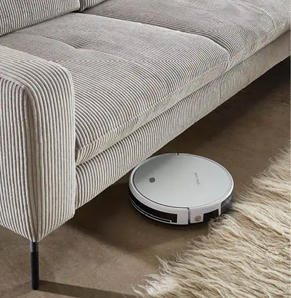 beiges Cordsofa mit Staugsauberroboter