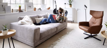 Modernes Wohnzimmer mit Cord-Sofa in Beige mit cognacfarbenem Relaxsessel.