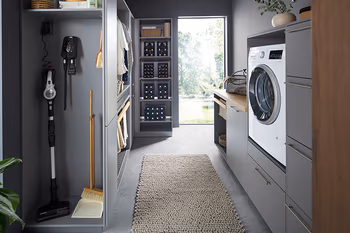 Ansicht eines schmalen Hauswirtschaftsraums mit verschiedenen Regalen und Schränken