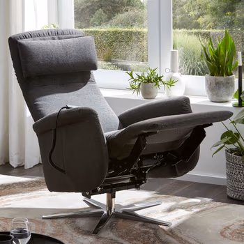 Grauer Relaxsessel mit nach hinten geklappter Rückenlehne und hochgeklappter Fußstütze.
