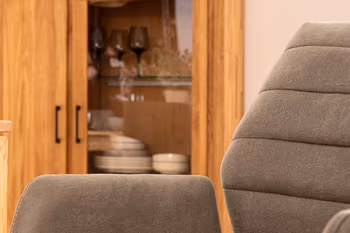 Rückenlehne eines grauen Armlehnstuhls, der eine quersteppung an der Rückenlehne hat.