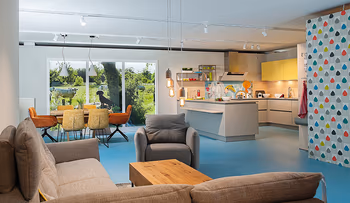 Bild aus der Ausstellung mit Polstermöbeln, Esstisch und Küche