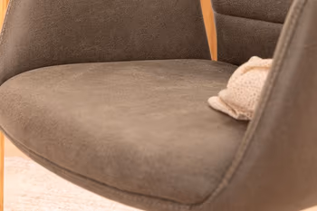 Sitzfläche eines grauen Armlehnstuhls aus der Nähe.