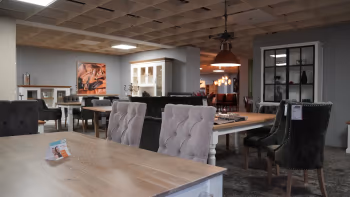 Esszimmer-Ausstellung in der Wohnwelt von Harten mit eleganten Stühlen und Massivholztischen in gemütlicher Atmosphäre.