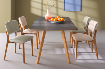 Esstisch mit HPL-Arbeitsplatte im Skandi Look um den mehrere weiße und grüne Stühle stehen. 