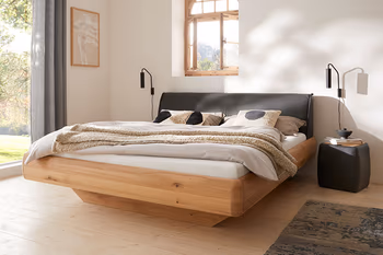 Designbett in schwebender Optik mit Holzrahmen und Leder Kopfteil. 