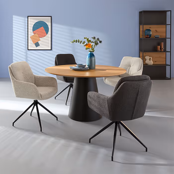 Runder Esstisch im Skandi Look, um den graue und weiße Armlehnstühle stehen.