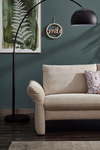 Armlehne eines beigen Sofas.