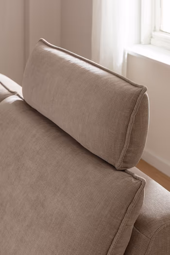 Bequeme Kopfstütze eines beigen Sofas.