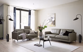 Klassisch eingerichtetes Wohnzimmer mit zwei grauen Ledersofas.