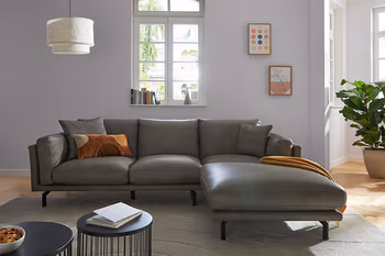 Graues Leder Ecksofa mit schwarzen Füßen.