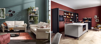 Cremefarbene Sofas in grünem Wohnzimmer und anthrazitfarbene Inselkueche.