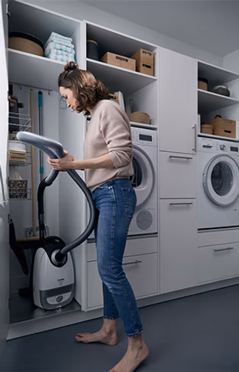 Putzschrank in einem weißen Schrank zum verstauen eines Staubsaugers