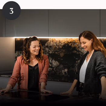 Nach fertig gestellter Planung stehen zwei Frauen zufrieden in einer Küche.