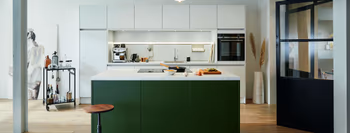 Designer Küche mit grüner Kücheninsel und weißen Schränken.