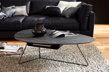 Designer Bestelltisch mit ovaler Tischplatte in schwarzem Keramiklook und schwarzem Metallgestell.