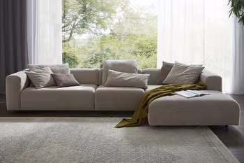 Großes beiges Design Ecksofa mit breiten Sitzflächen. 
