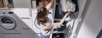 Frau verstaut Wäsche in Hauswirschaftsruam