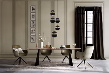 Großer moderner Esstisch mit Massivholz Tischplatte und schwarzem Metallfußgestell in einem Raum mit hoher Decke und grauen Armlehnstühlen.