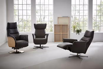 Drei schwarze Relaxsessel nebeneinander, der linke hat an der außenseite der Lehne Holzverkleidung, der rechte ist in Relaxposition.