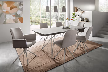 Schwarzer Esstisch und Esszimmerstühle mit hellem Gestell. 