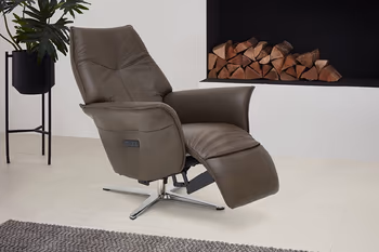 Braungrauer Relaxsessel in einem hellen Raum mit Holz.