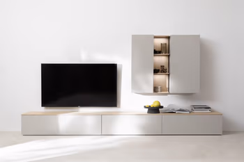 Moderne graue Wohnwand bestehend aus einem großen Lowboard mit einer Holzplatte oben und einem hängenden Regal mit grauen Türen und dazwischen drei Regalböden in Holz.