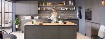 Frau genießt ein Getränk in eine Betonküche