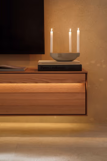 TV-Lowboard aus Eiche mit beleuchteter Griffleiste.