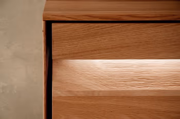 Beleuchtete Griffleiste einer Wohnwand aus Eiche.