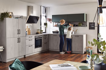 Hellgraue Betonküche kombiniert mit dunklem Holzboden.