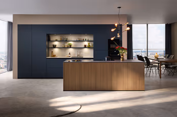 Moderne Design Wohnküche von Contur mit Kücheninsel in Holz und blauen Schränken.