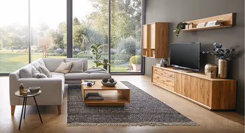 Wohnzimmereinrichtung mit Holzwohnwand und hellgrauem Stoffsofa