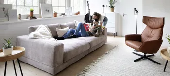 Modernes Wohnzimmer mit Cord-Sofa in Beige mit cognacfarbenem Relaxsessel.