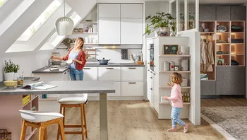 Helle Familienküche mit Dachschrägen, moderner Einrichtung und viel Stauraum, Mutter und Kind beim gemeinsamen Alltag.