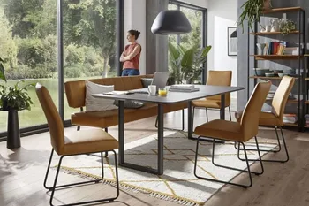 Sitzbank und Stühle mit gelbem Leder und schwarzem Metallgestell um einen modernen Esstisch.