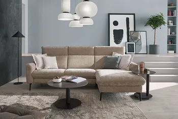 Beiges Ecksofa mit aufklappbaren Rückenlehnen und schwarzen Füßen in einem hellen Raum. 