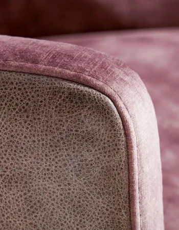 Armlehne eines Sessels der außen mit Leder und innen mit Stoff in mauve bezogen ist.